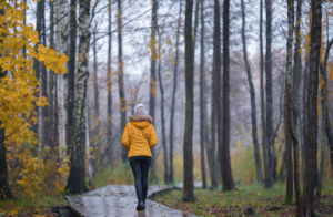 Woman walking through woods in autumn