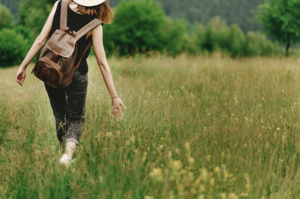 Mental health benefits of walking - Woman walking through meadow