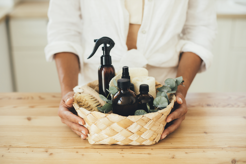 Spring cleaning tips: Woman holding basket of cleaning products